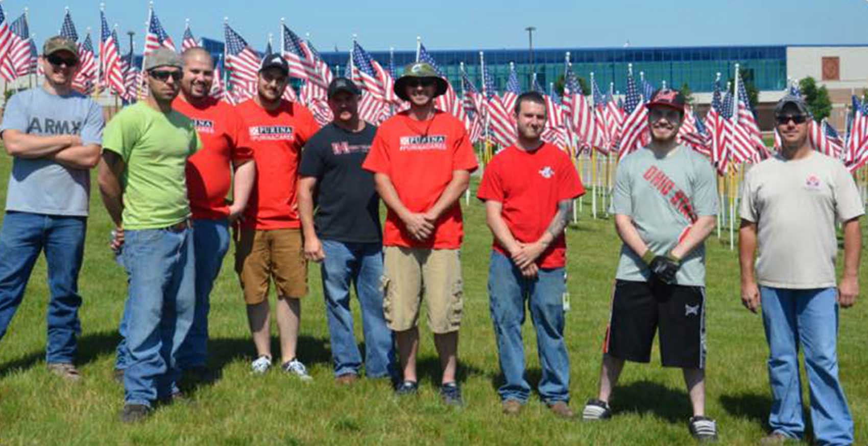 Group of associates standing in front of American flags